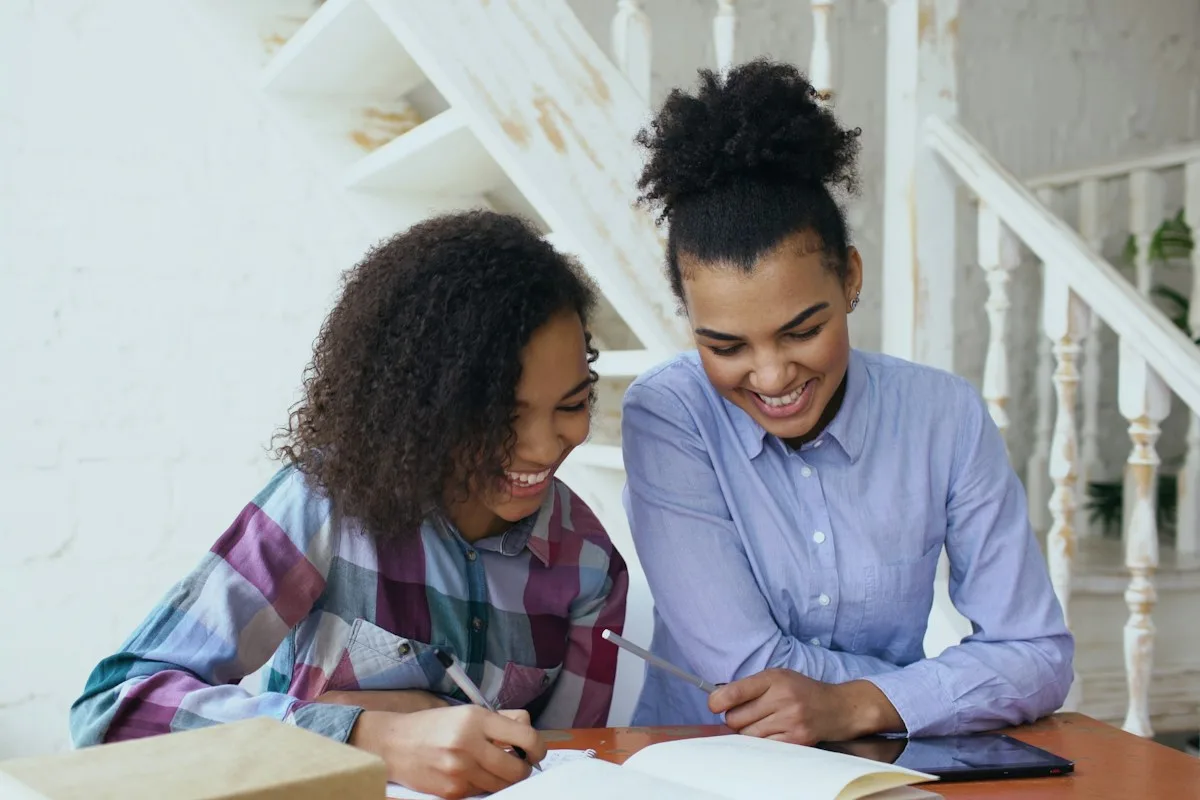 Teenage student and an adult at a table working through college paperwork together
